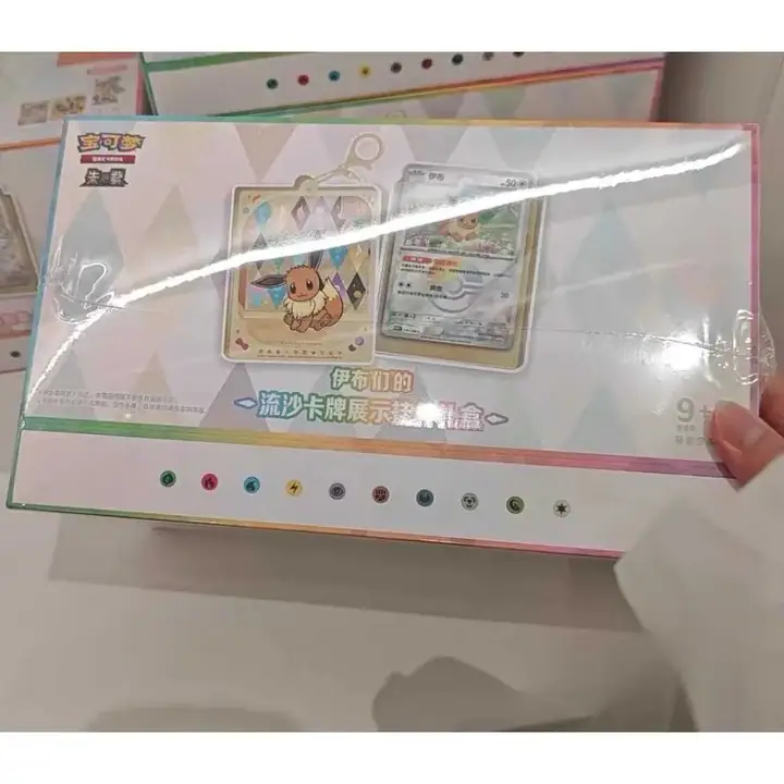Eevee display-pendant outer package behind reflective wrapping, with illustrated card holders and a card on the front